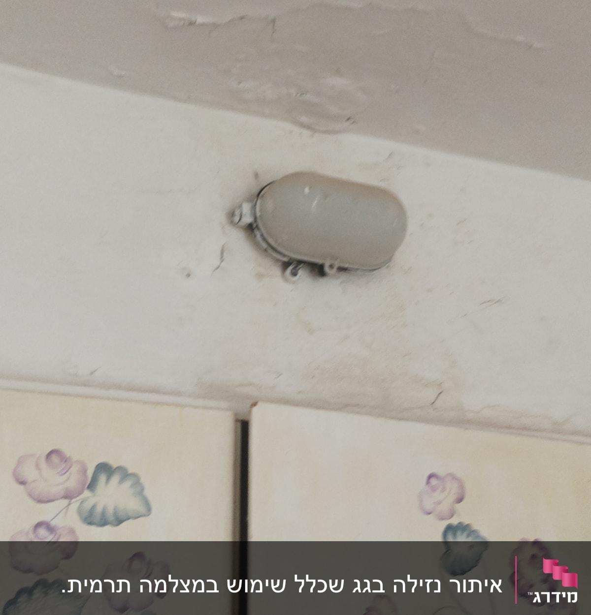 תקרה עם סימני רטיבות ומנורה מותקנת
